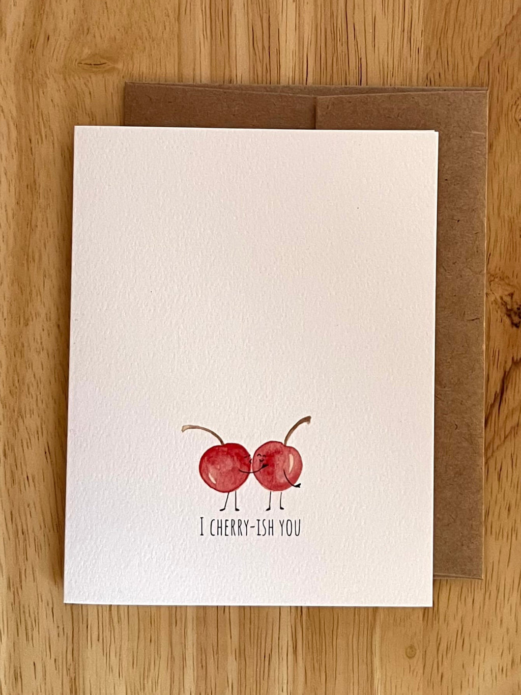 'I Cherry-ish You' watercolor pun card. Features two cherries kissing—a sweet and funny choice for Valentine's Day or anniversaries.