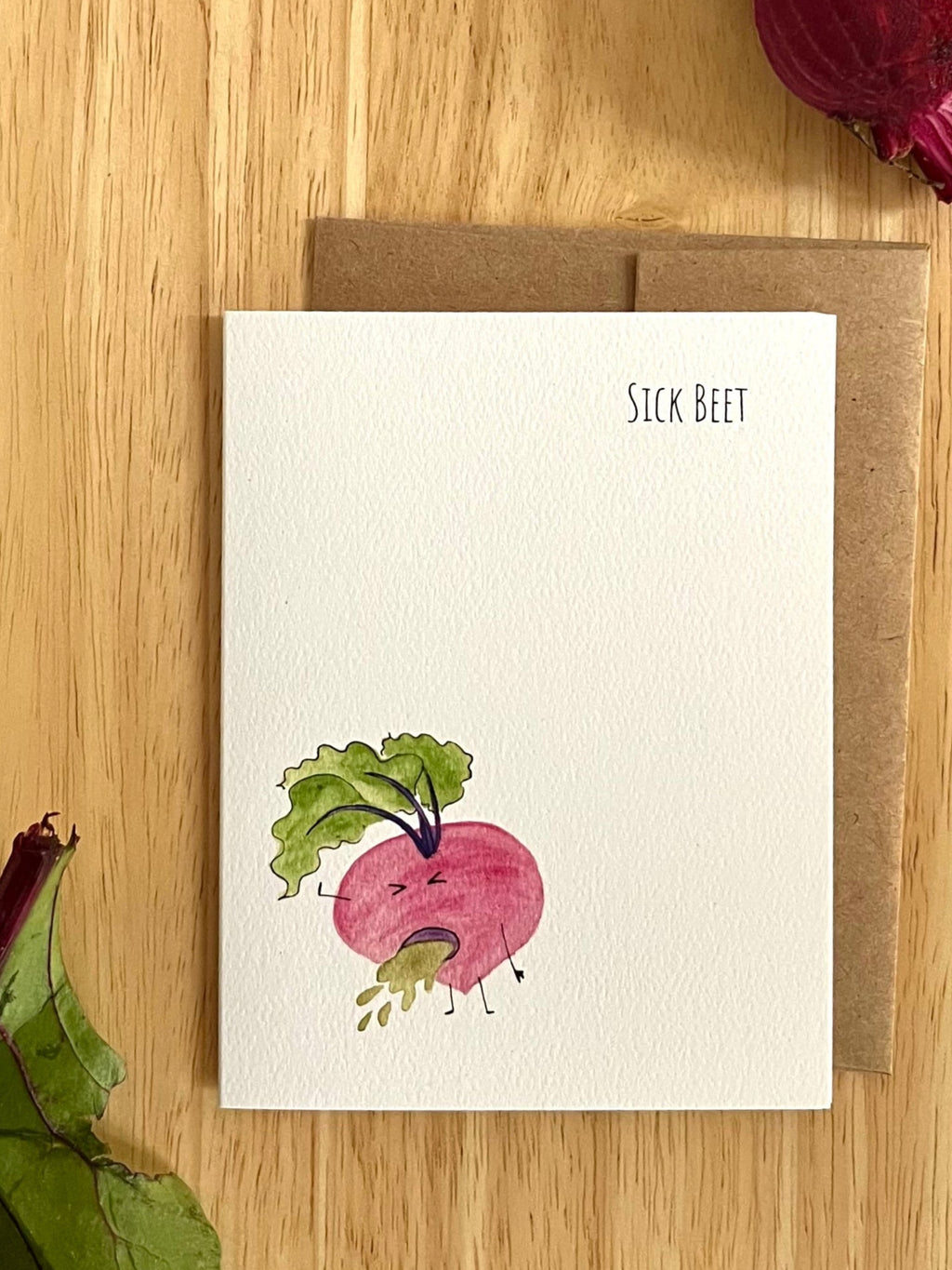 Mei Pie Studio Greeting card with a beet illustration and envelope on a wooden surface
