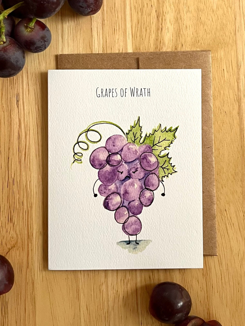 Mei Pie Studio Greeting card with grape illustration on a wooden surface with grapes around