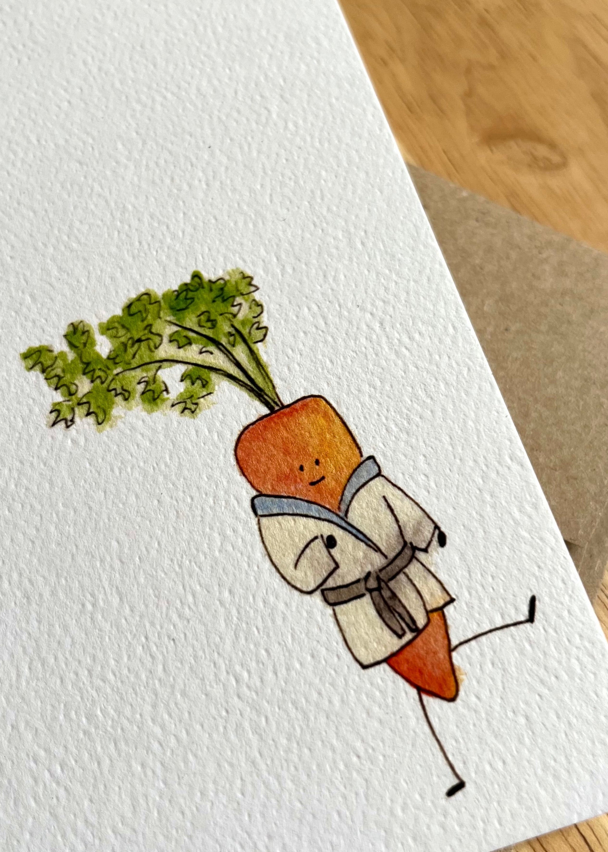 Card with a carrot character holding a sprig of parsley on a wooden surface