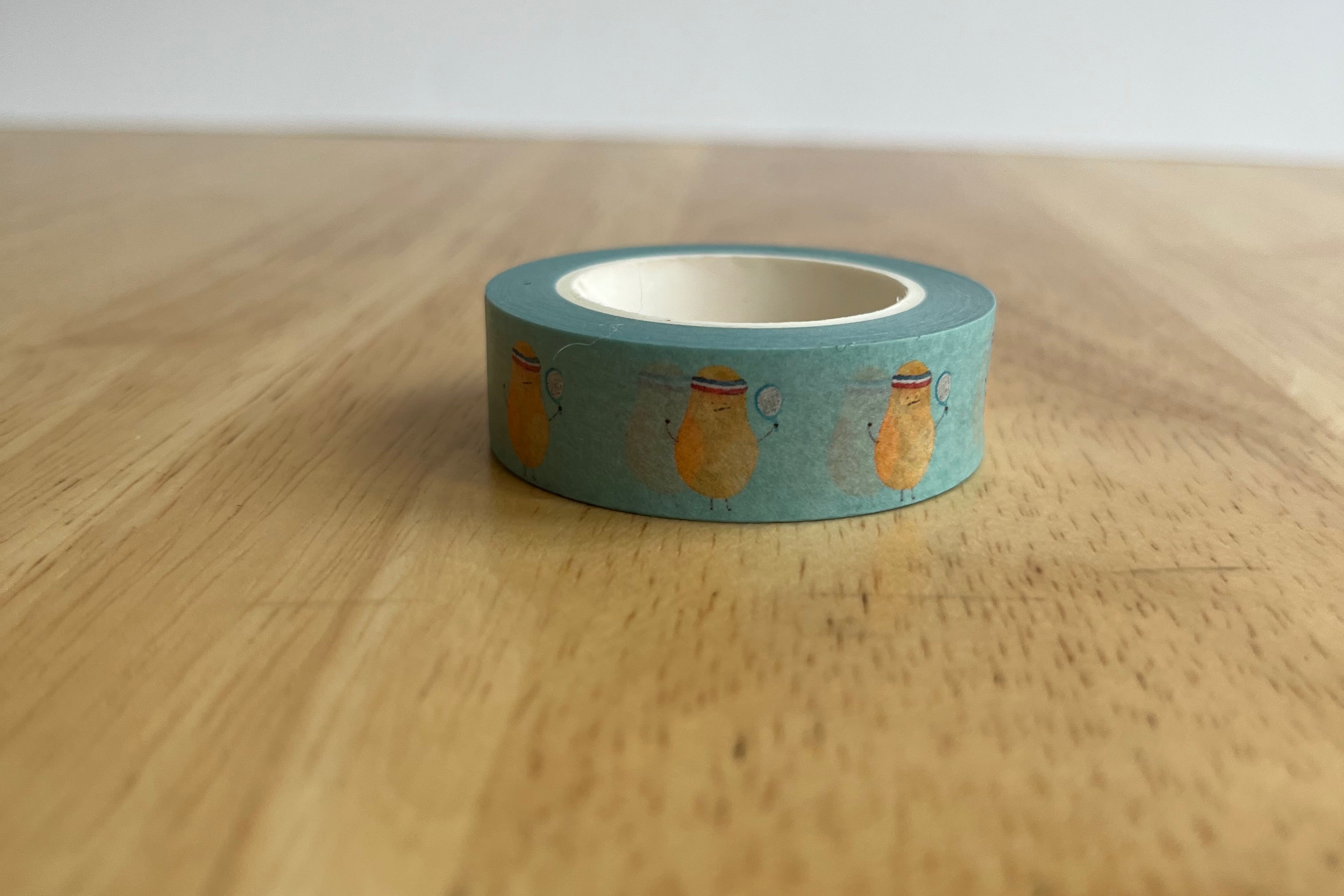 Blue washi tape with gold patterns on a wooden surface