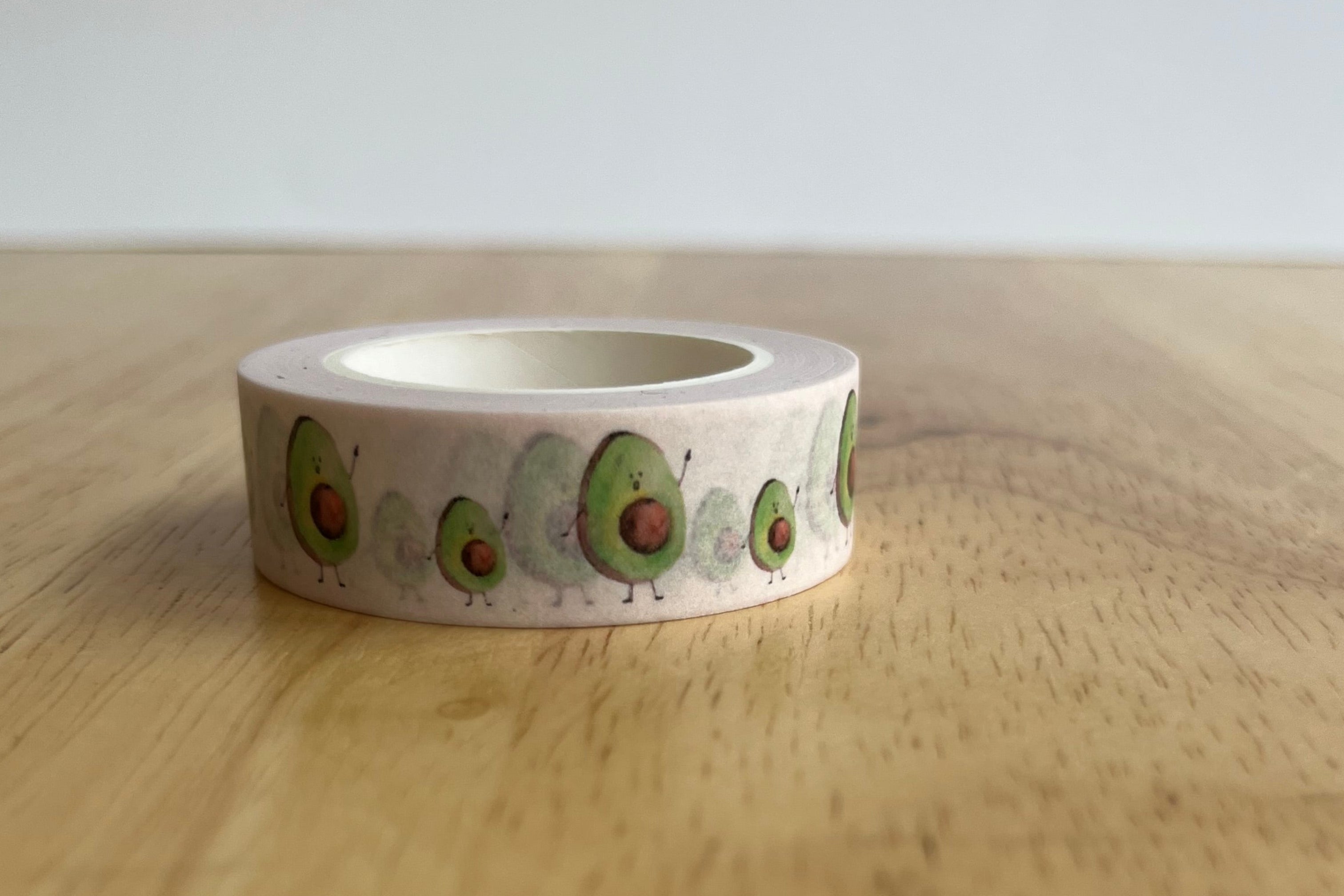 Roll of decorative tape with avocado design on a wooden surface