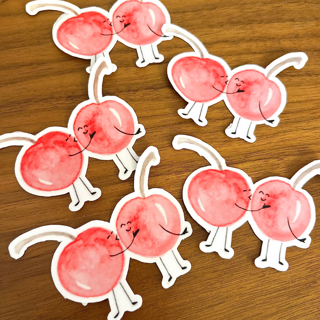 pile of Die-cut vinyl stickers of cherries kissing. I cherry-ish you