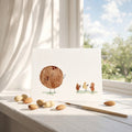 Coconut illustration on a card with peanuts and a paintbrush on a windowsill
