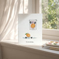 Greeting card with a cartoon orange character on a windowsill with a view of greenery.