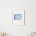 A light natural wood crib with white bedding in a bright, minimalist nursery with a white wall, a wooden shelf, and a small framed print of a blueberry moon.