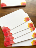 mei pie studio minimalist water color orange, red and yellow sunburst mini note set  on classic crest neenah stock. close up on a wooden table